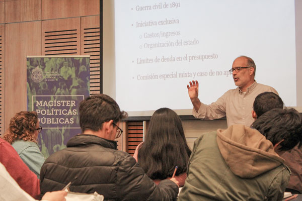 El académico dicta diversos cursos en la UC,. En la foto, durante una clase en el Magíster en Políticas Públicas.