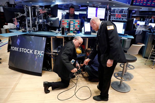 Operadores de la bolsa de Nueva York remueven sus computadores para comenzar a trabajar desde la casa, mientras el edificio se prepara para cerrar indefinidamente. Foto: Reuters