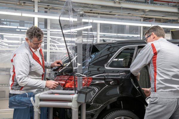 Dos trabajadores produciendo un coche en una planta de Audi.EuropaPress