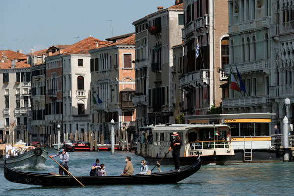 Los gondoleros debieron usar mascarillas para poder retomar el servicio en el Gran Canal de Venecia, a medida que Italia intenta volver a la normalidad. Foto: Reuters