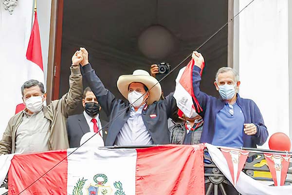 Pedro Castillo saluda a sus partidarios junto a Pedro Francke (derecha) y Hernando Cevallos (izquierda).