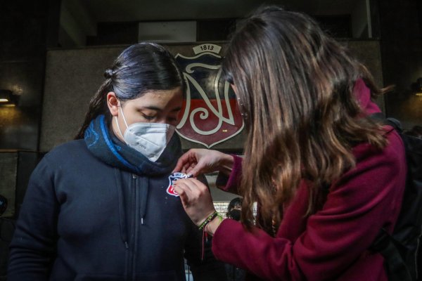 La alcaldesa de Santiago, Irací Hassler, le coloca una insignia a una alumna. Foto A1.
