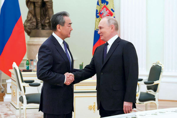 El consejero de Estado chino, Wang Yi, saluda al Presidente de Rusia, Vladimir Putin, en el marco de una reunión ayer en Moscú.