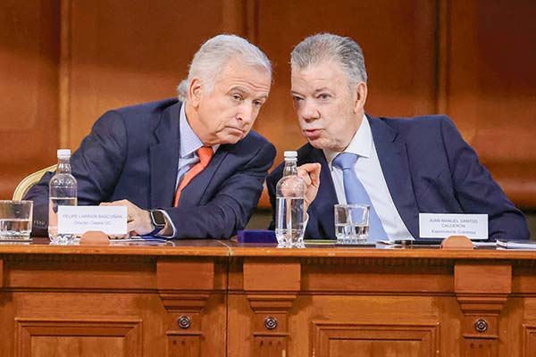 El exministro de Hacienda y editor del libro, Felipe Larraín, junto a Juan Manuel Santos.