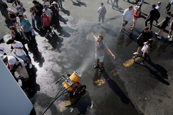 <p>Un hombre se refresca frente a un rociador de agua mientras los visitantes hacen fila para rellenar sus botellas cerca de París. (Foto: Reuters)</p>