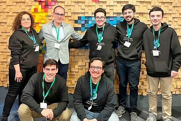 Cristóbal Langdon (de pie y con chaqueta), junto al equipo de Speaknosis.