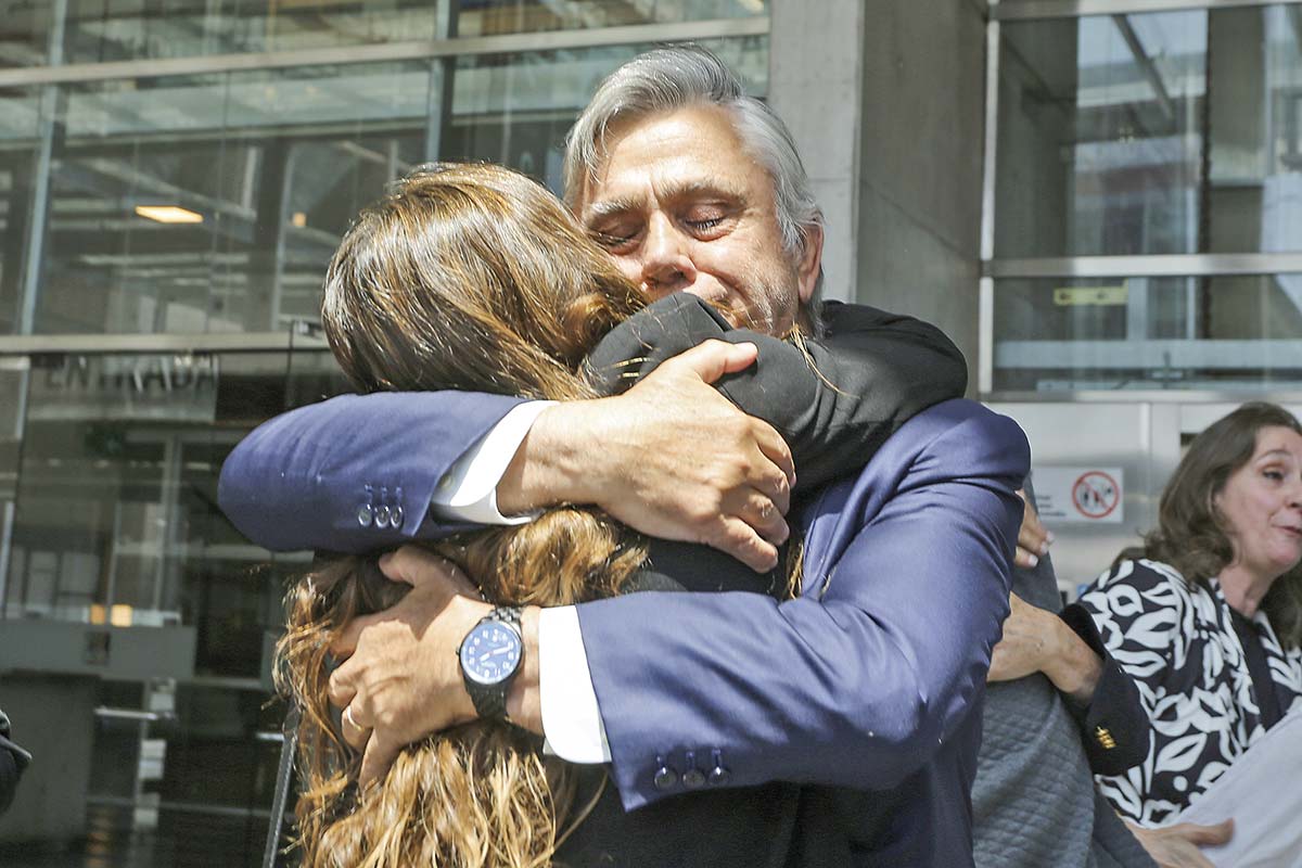 <p>Pablo Longueira abrazando a una de sus hijas a la salida del tribunal. Fotos: José Montenegro.</p>