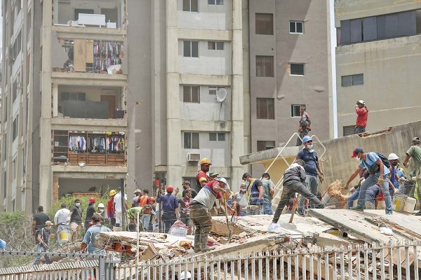 <p>Personas buscan víctimas entre los escombros de un edificio derrumbado en Caracas. Foto: Reuters</p>