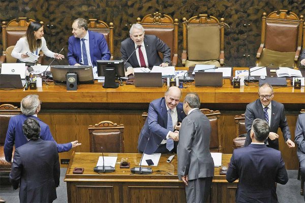 <p>Los ministros Quiroz y García celebran la aprobación de los vetos, revirtiendo un revés en la comisión de Hacienda más temprano, que rechazó dos de los tres vetos del Ejecutivo. Foto: Aton.</p>