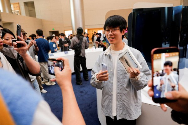 El orgullo primer comprador del iPhone Duo en la tienda Apple del barrio de Jing'an en Shanghai. (Fotos: Reuters)